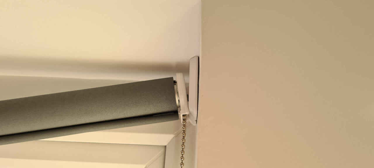 Fitting the roller blind fixed end locating lugs into the mounting bracket